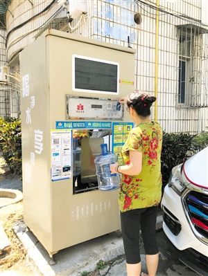 5月24日，瓊山區(qū)上丹花苑小區(qū)居民陳女士在使用共享凈水機(jī)取水。 本報記者 陳歆卓 攝